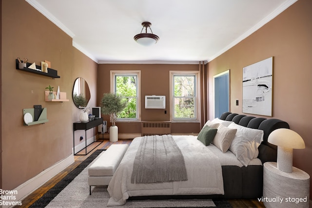 bedroom featuring a wall unit AC, crown molding, wood finished floors, baseboards, and radiator heating unit