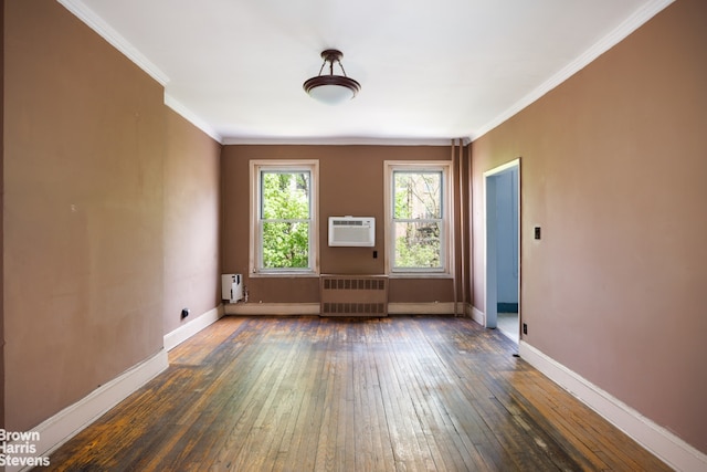 spare room with wood-type flooring, radiator, a wall mounted AC, and baseboards