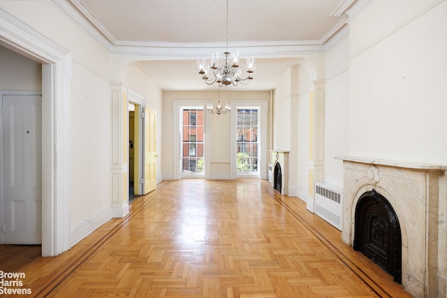 interior space with crown molding, radiator, baseboards, a chandelier, and arched walkways