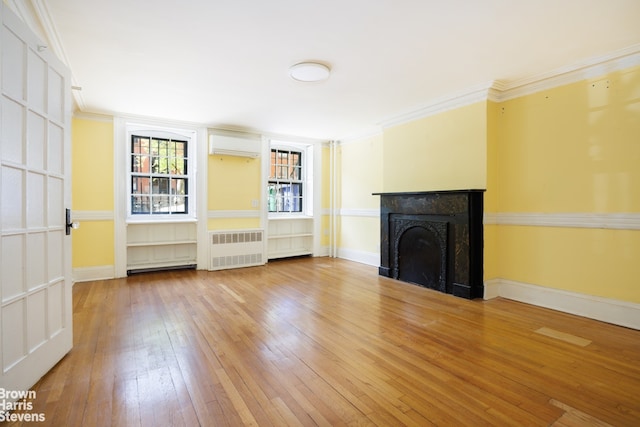 unfurnished living room featuring ornamental molding, light wood finished floors, radiator, and a fireplace