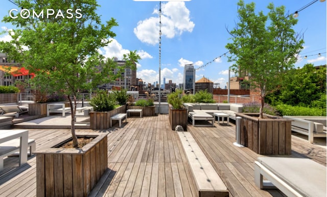 wooden deck with a view of city and an outdoor hangout area