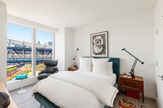 bedroom with baseboards and wood finished floors