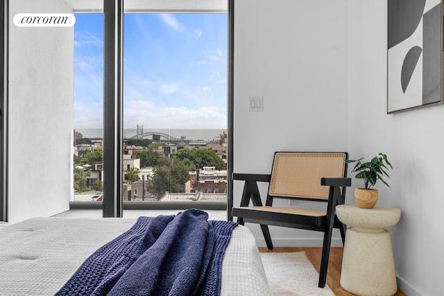bedroom with a city view and wood finished floors