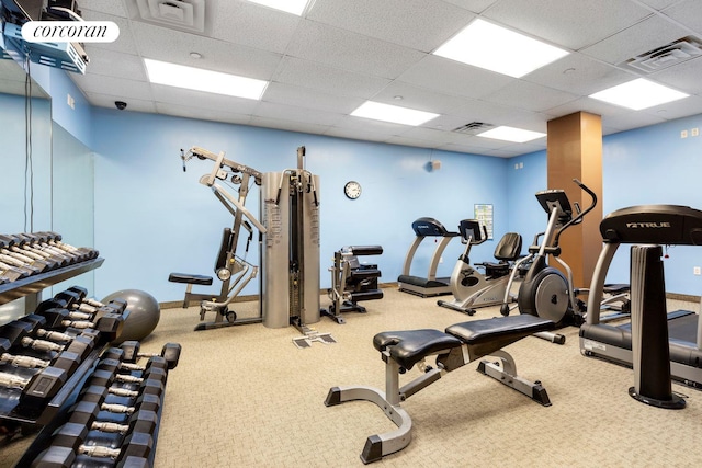 exercise room featuring carpet flooring, a paneled ceiling, and visible vents