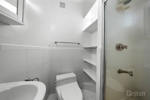 full bathroom with tile walls, a stall shower, toilet, and visible vents