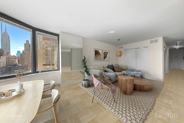 living room with visible vents, a city view, and baseboards