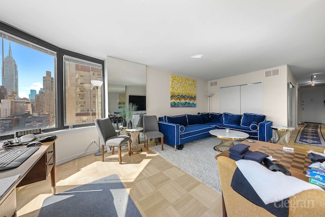 living room featuring visible vents and a view of city