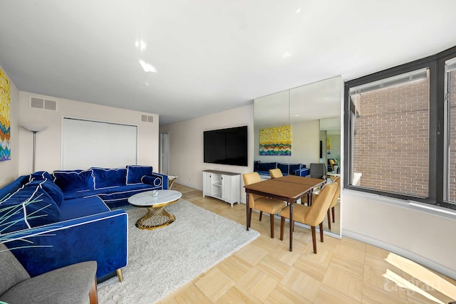 living room featuring baseboards and visible vents