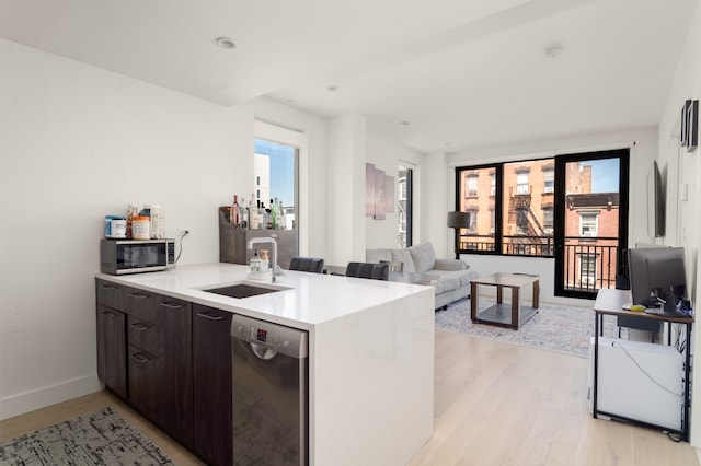 kitchen with stainless steel appliances, a sink, light wood-style floors, healthy amount of natural light, and recessed lighting