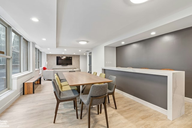 dining area featuring recessed lighting, baseboards, an accent wall, and light wood-type flooring