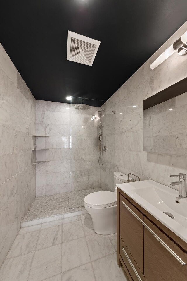 141 W 126th St Unit 4A, New York City, NY 10027 - bathroom with tile walls, toilet, a walk in shower, vanity, and marble look tiles