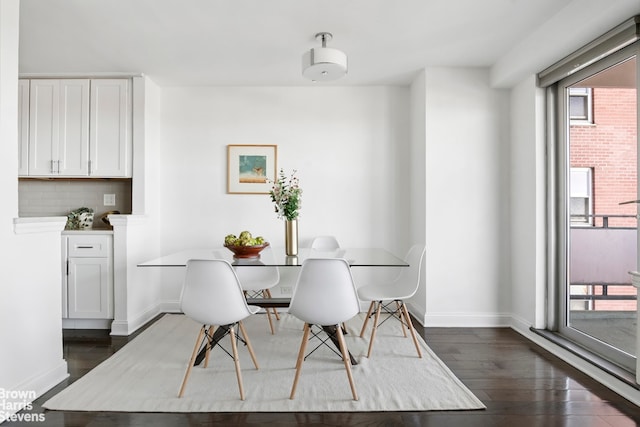 dining area with baseboards and dark wood-type flooring