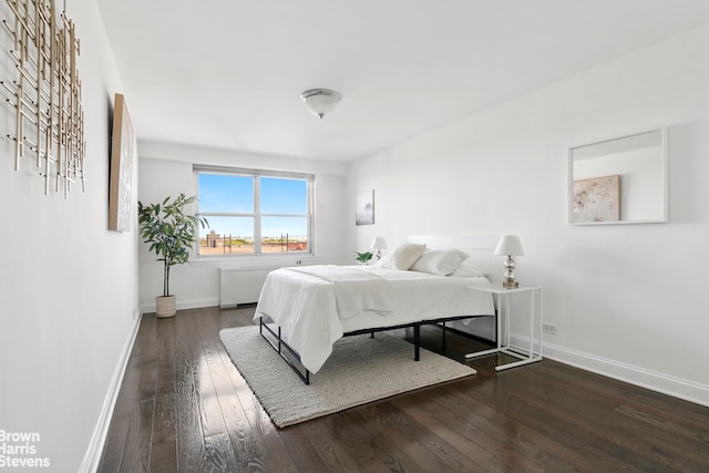 bedroom with baseboards, radiator heating unit, and hardwood / wood-style floors