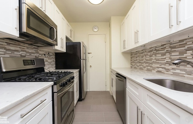 3050 Fairfield Ave Unit 3F, New York City, NY 10463 - kitchen featuring appliances with stainless steel finishes, a sink, white cabinets, and decorative backsplash
