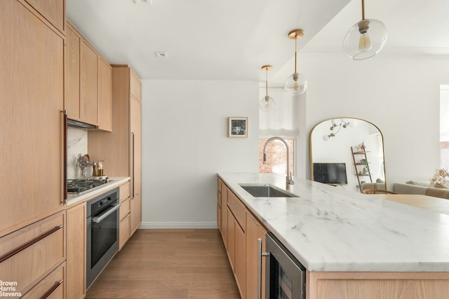350 W 71st St Unit 2F, New York City, NY 10023 - kitchen with wine cooler, a peninsula, light brown cabinets, a sink, and stainless steel appliances
