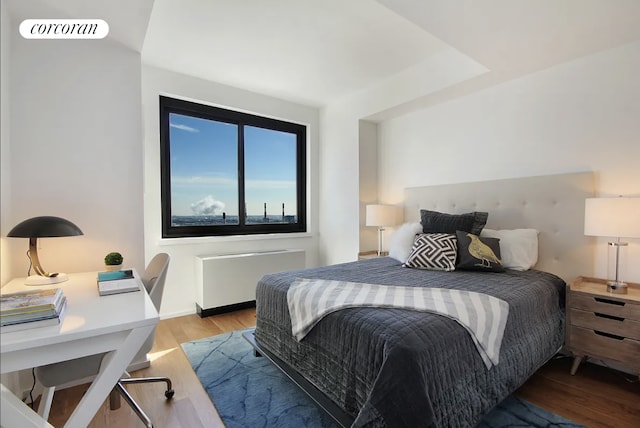 bedroom with light wood-type flooring, radiator, and visible vents
