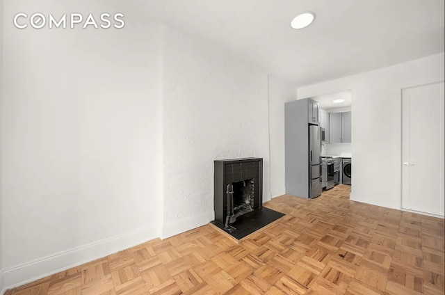 130 W 80th St Unit 5R, New York City, NY 10024 - unfurnished living room with a fireplace, baseboards, and washer and clothes dryer