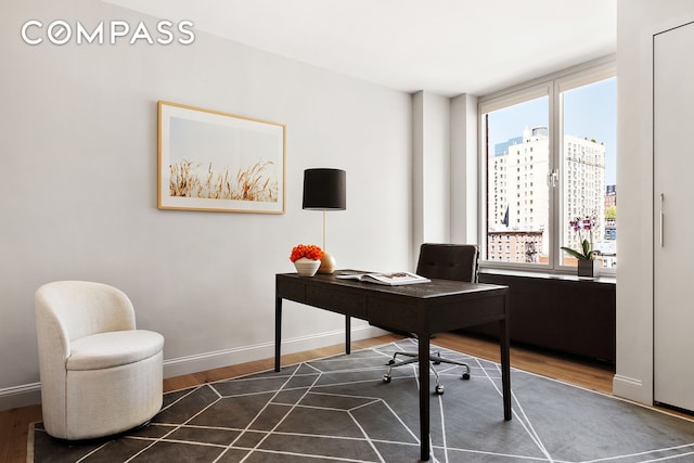 office space featuring baseboards, a view of city, and dark wood-style floors