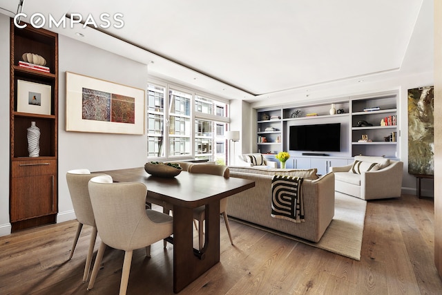 interior space featuring built in features, baseboards, and wood finished floors