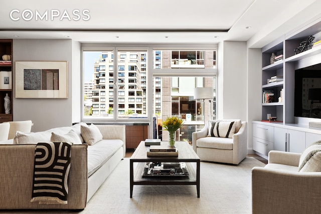 living area with recessed lighting, built in shelves, and a wealth of natural light