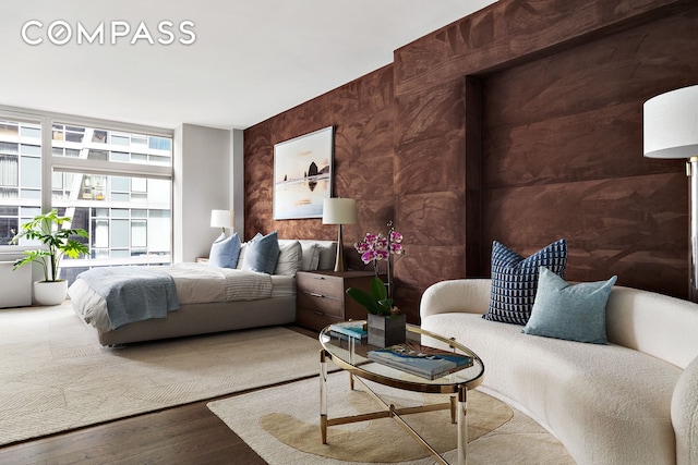 bedroom featuring wood finished floors and expansive windows