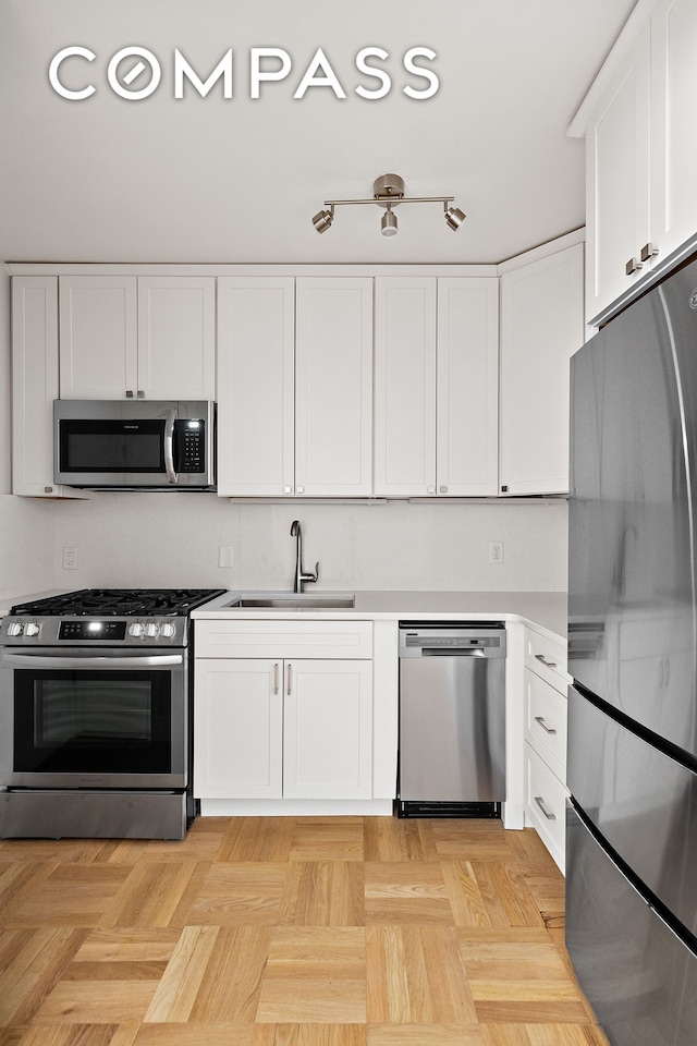 49 W 12th St Unit 1A, New York City, NY 10011 - kitchen with appliances with stainless steel finishes, a sink, white cabinetry, and light countertops