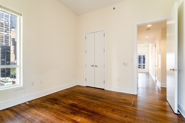 250 E 49th St Unit 10A, New York City, NY 10017 - empty room with plenty of natural light, dark wood-style floors, and baseboards