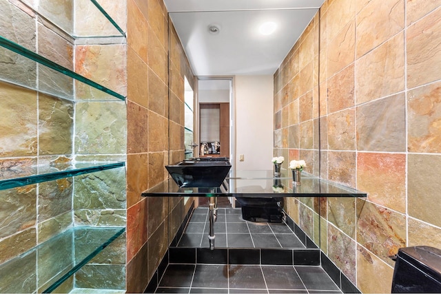 bathroom with a sink, tile walls, and tile patterned flooring