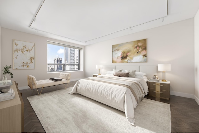 bedroom with baseboards, rail lighting, and a city view