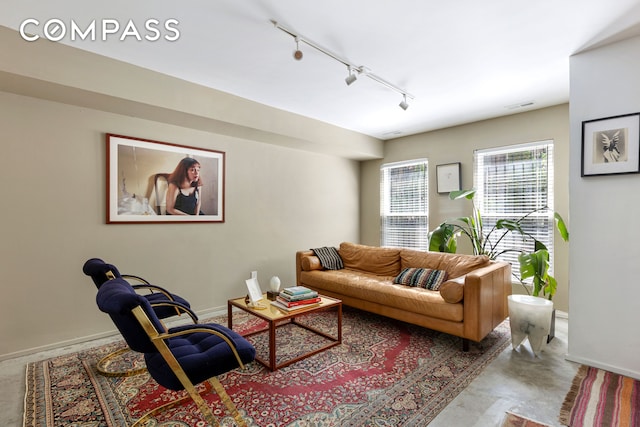 living area with baseboards, rail lighting, and visible vents