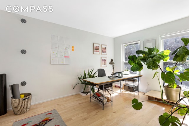 office area with baseboards and light wood-style floors