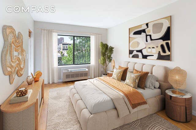 bedroom with wood finished floors and a wall mounted AC