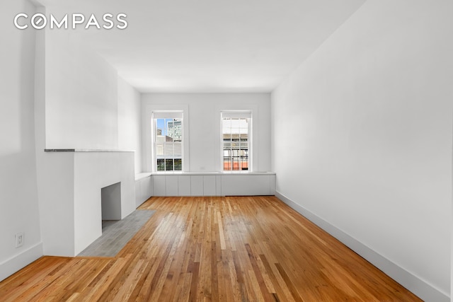unfurnished room featuring wood-type flooring and baseboards