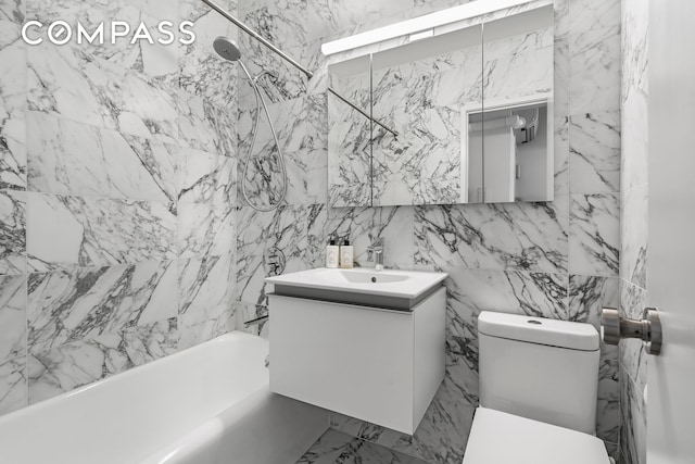 bathroom featuring toilet, tile walls, shower / bathing tub combination, and vanity