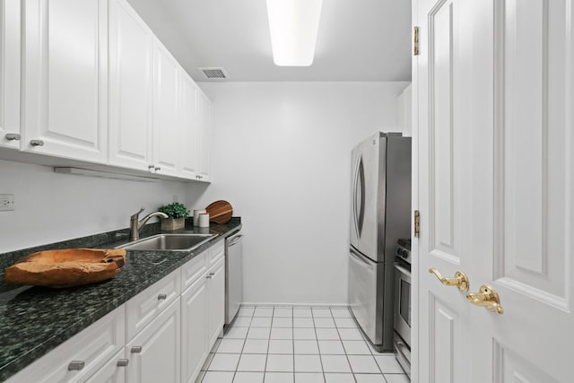 kitchen with visible vents, appliances with stainless steel finishes, white cabinetry, a sink, and light tile patterned flooring