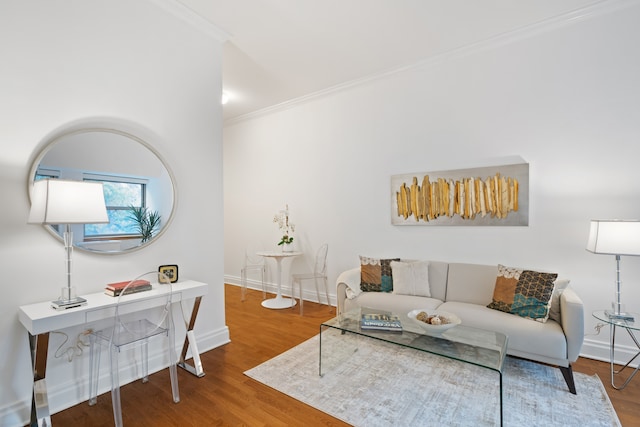 living area featuring crown molding, baseboards, and wood finished floors
