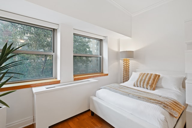 bedroom with crown molding and wood finished floors