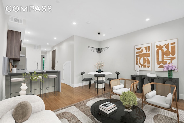 living area featuring visible vents, recessed lighting, and light wood-type flooring