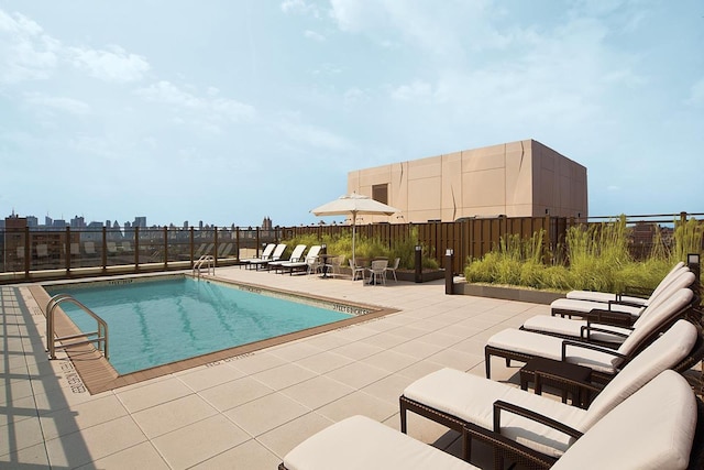 community pool with a patio and fence