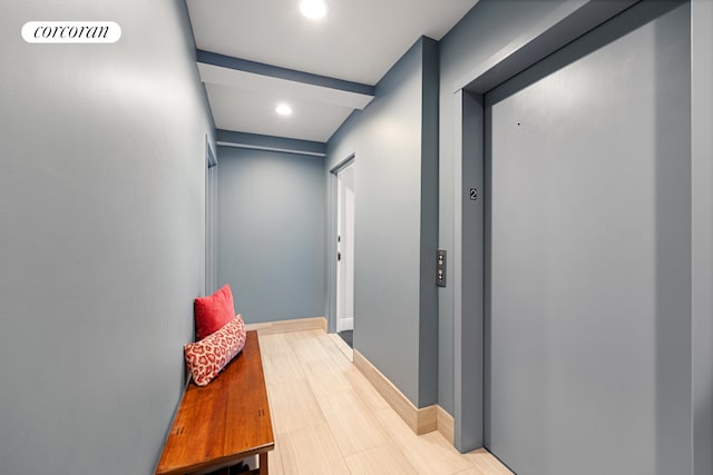 hall featuring recessed lighting, baseboards, and elevator