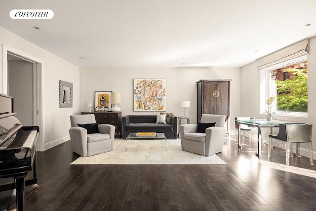 living area featuring baseboards, visible vents, and hardwood / wood-style flooring