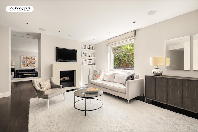 living area with baseboards, a fireplace, wood finished floors, and visible vents