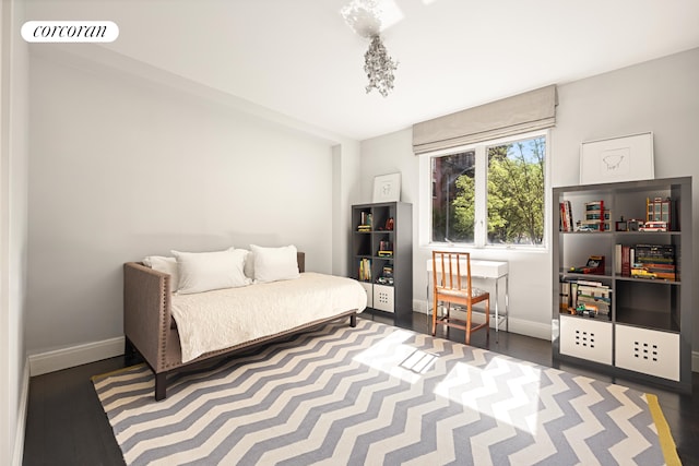 bedroom with baseboards, wood finished floors, and visible vents