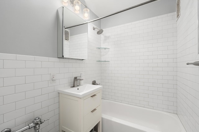 bathroom with shower / bath combination, vanity, and tile walls
