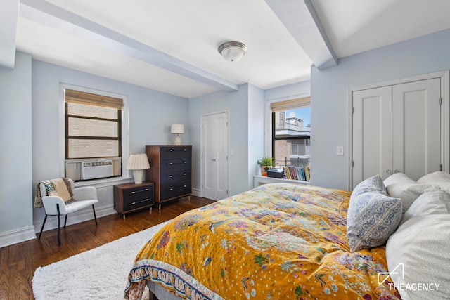 bedroom with multiple closets, baseboards, beamed ceiling, and dark wood-style floors