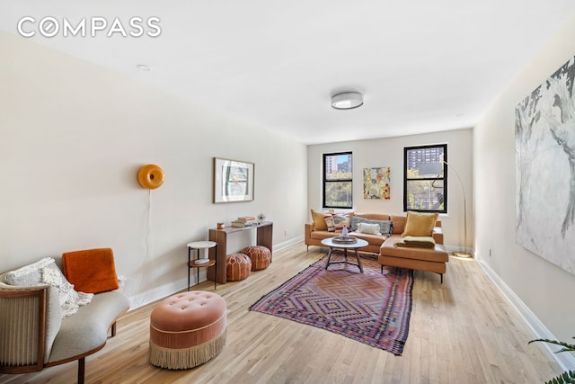 living area with baseboards and wood finished floors
