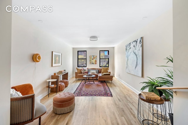 sitting room with baseboards and wood finished floors