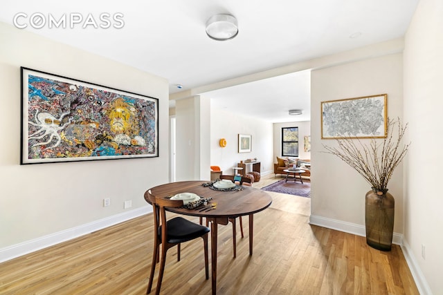 dining room featuring baseboards and light wood-type flooring