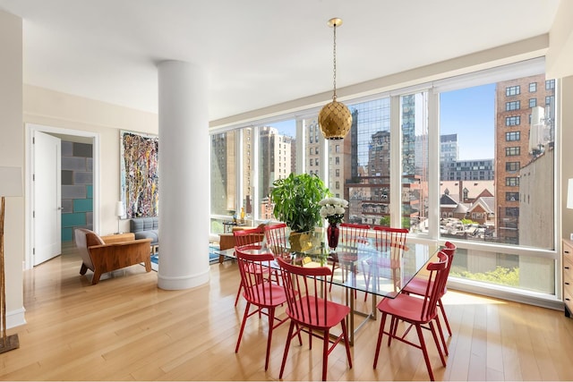 245 W 99th St Unit 7B, New York City, NY 10025 - dining area with a city view, light wood-style floors, decorative columns, and baseboards