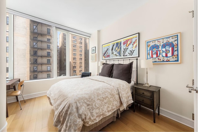 245 W 99th St Unit 7B, New York City, NY 10025 - bedroom with wood-type flooring, multiple windows, and baseboards